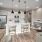 kitchen with white cabinets and island with stools beneath three pendant lights