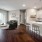 kitchen with white cabinets and island with stools opening to living area with sofa
