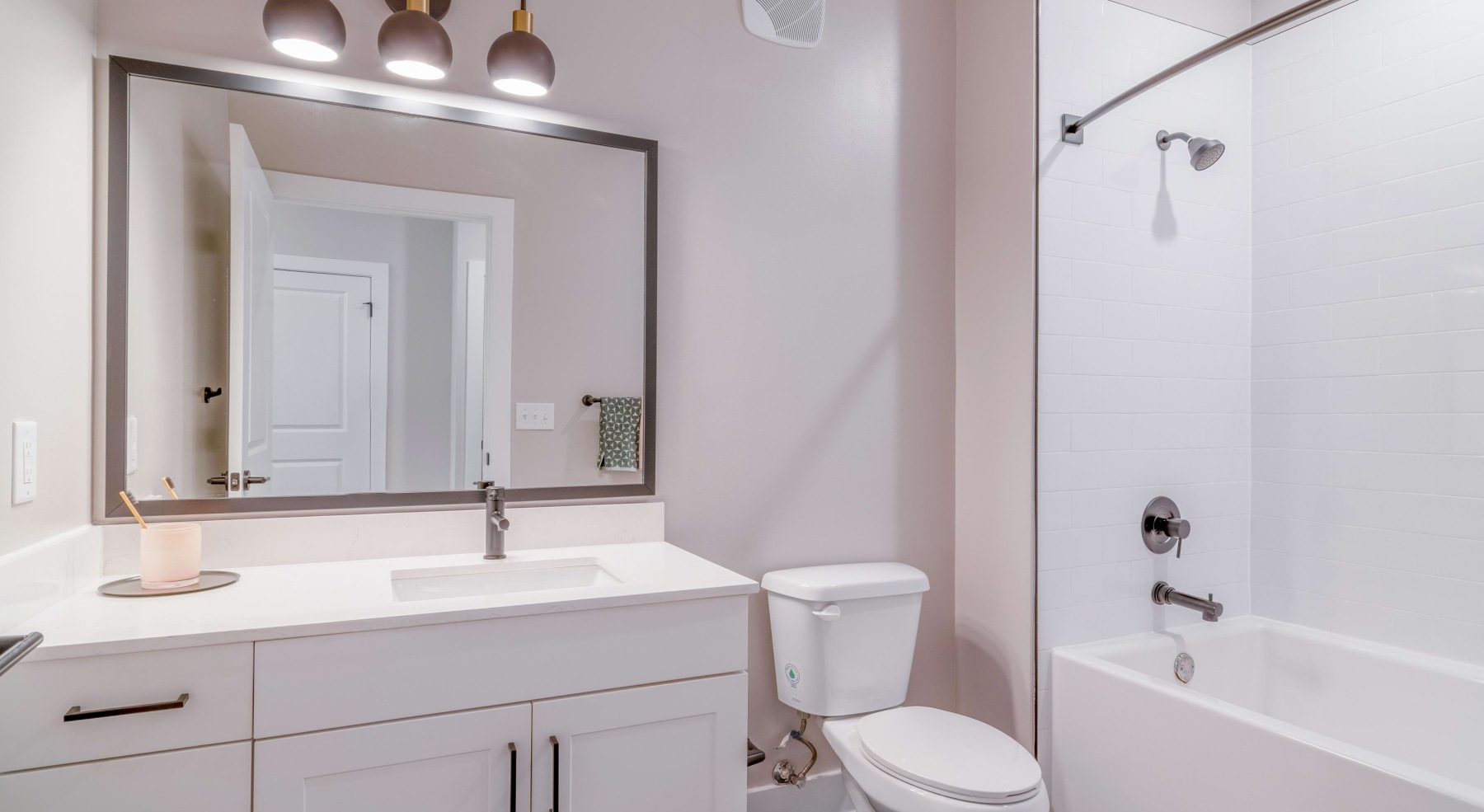 a spacious bathroom with a large mirror and ample light