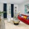 Model living room at our apartments in Atlanta, featuring wood grain floor paneling and a red couch.